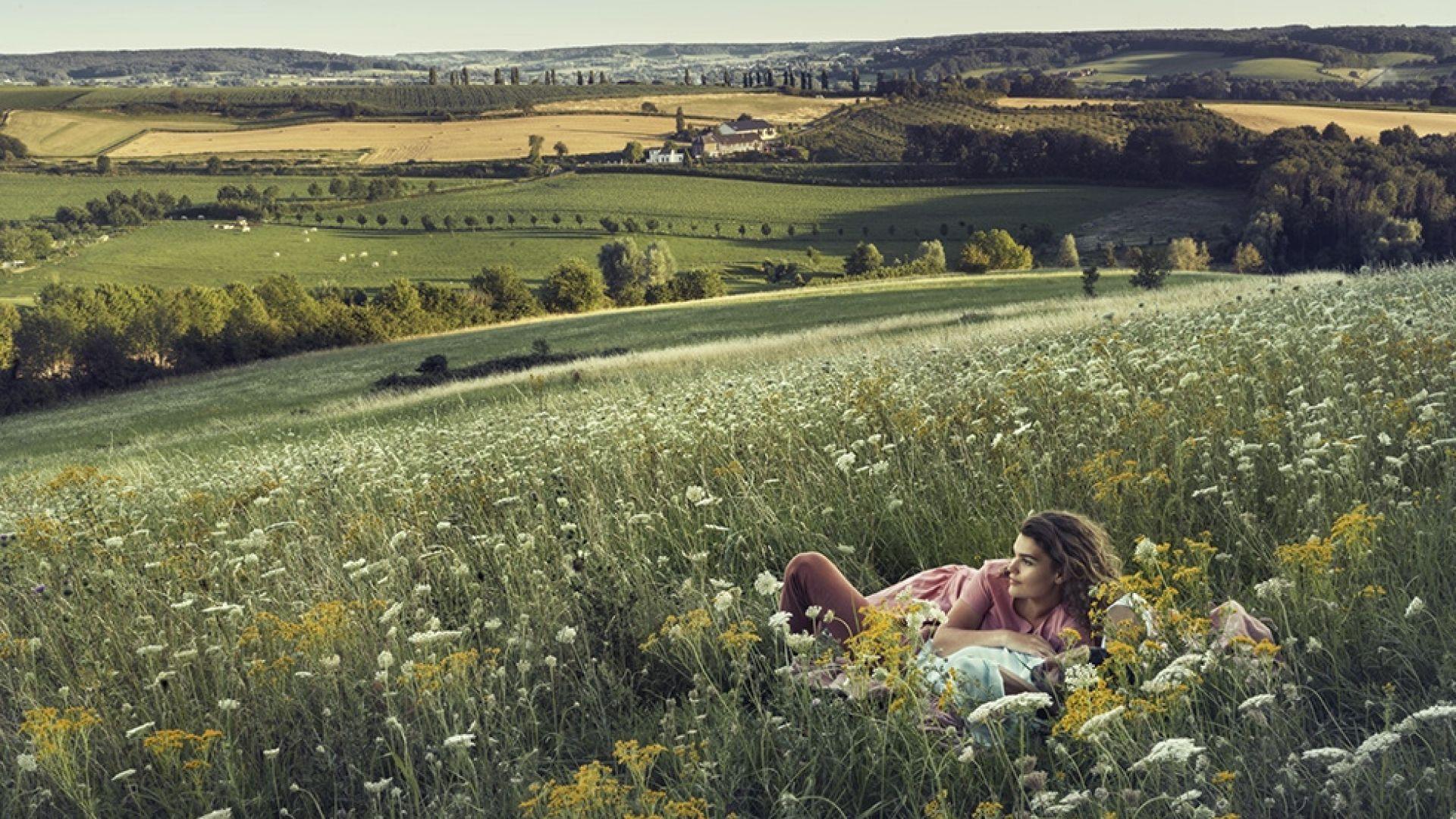 Vrouw ligt in het gras op een berg